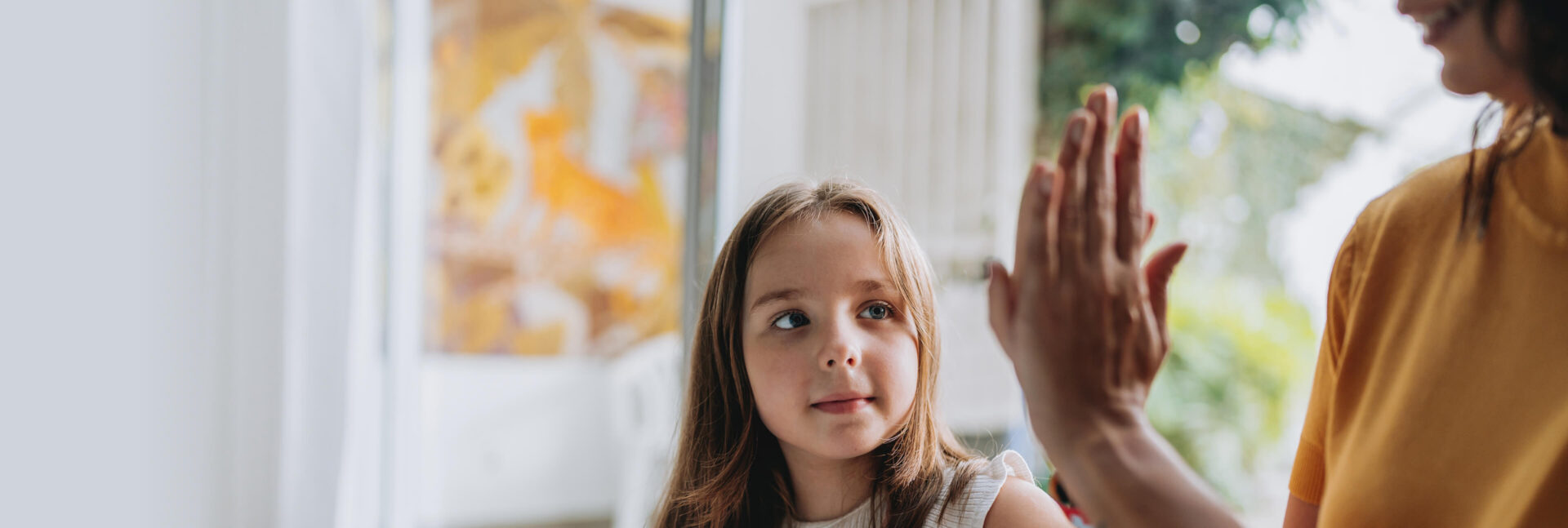 A girl high-fiving an adult